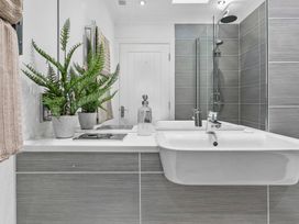 A bathroom with a sink and shower at The Renior Sea View Suite in Torquay