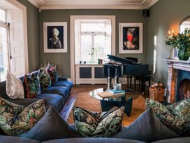 A living room with a piano and artwork at St Anne's Manor in Torquay