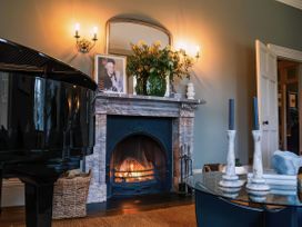 A living room featuring a piano, fireplace, and decorative items at St Anne's Manor in Torquay
