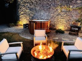 An outdoor seating area with a fire pit and hot tub at St Anne's Manor in Torquay