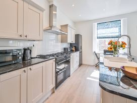 A kitchen with various appliances and a sink at The Falstone Apartment in Torquay