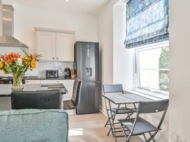 A kitchen with refrigerator and table at The Falstone Apartment in Torquay