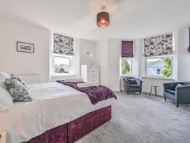 A bedroom with a bed and armchairs at The Falstone Apartment in Torquay