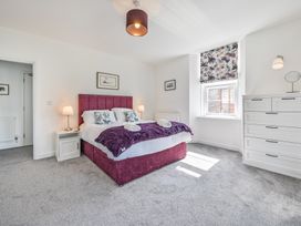 A bedroom with a bed and dressers at The Falstone Apartment in Torquay