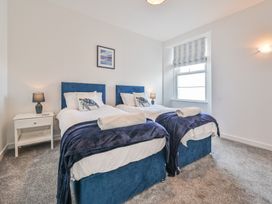 A bedroom with two twin beds and a bedside table at The Falstone Apartment in Torquay