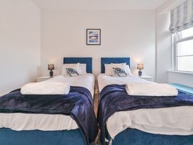 A bedroom with two single beds and a window at The Falstone Apartment in Torquay