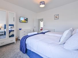 A bedroom with a bed and a television at The Falstone Apartment in Torquay