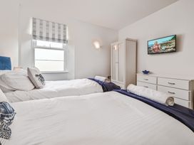 A bedroom with two beds and a television at The Falstone Apartment in Torquay