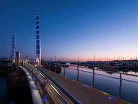A marina with a boardwalk and yachts at The Falstone Apartment in Torquay