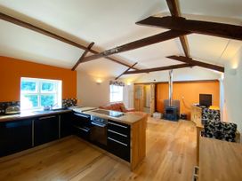A kitchen with a sofa and television at Upper Stable - The Stables Apartments at Meadfoot Bay, Torquay
