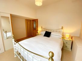 A bedroom with a bed and nightstand at Upper Stable - The Stables Apartments at Meadfoot Bay in Torquay