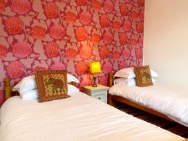 A bedroom with two beds and a lamp at Upper Stable - The Stables Apartments at Meadfoot Bay Torquay