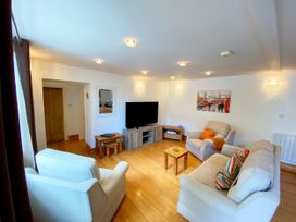 A living room with a television and sofa at Lower Stable - The Stables Apartments at Meadfoot Bay, Torquay
