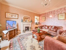 A living room with a television and sofa at Muntham Luxury Town House with Hot Tub in Torquay