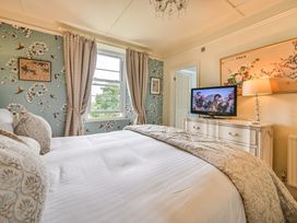 A bedroom with a bed and a television at Muntham Luxury Town House with Hot Tub Torquay