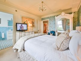 A bedroom with a bed and television at Muntham Luxury Town House with Hot Tub in Torquay
