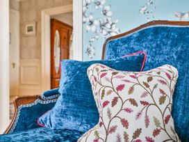 A living room with a blue sofa and decorative pillow at Muntham Luxury Town House with Hot Tub in Torquay