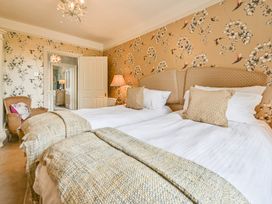A bedroom with beds and a chair at Muntham Luxury Town House with Hot Tub in Torquay