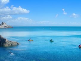 A view of kayaks on the ocean with rocky shore at Muntham Luxury Town House with Hot Tub Torquay