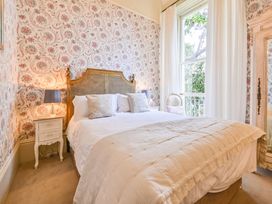 A bedroom with a bed and bedside table at Muntham Deluxe Apartment 2 in Torquay