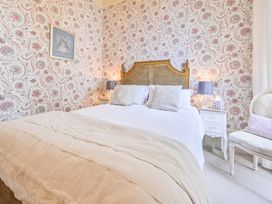A bedroom with a bed, nightstand, and lamps at Muntham Deluxe Apartment 2, Torquay