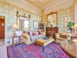 A living room with a sofa, armchairs, and a fireplace at Muntham Deluxe Apartment 3, Torquay