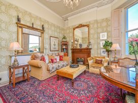 A living room with a fireplace and sofa at Muntham Deluxe Apartment 3 in Torquay
