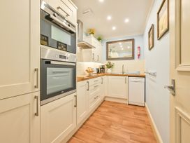 A kitchen with appliances and cabinets at Muntham Deluxe Apartment 3 in Torquay