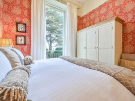 A bedroom with a bed and wardrobe at Muntham Deluxe Apartment 3, Torquay