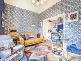 A living room with a yellow sofa and dining table at Muntham Apartment 4 in Torquay