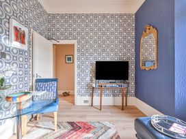 A living room with a glass table and blue chair at Muntham Apartment 4 in Torquay