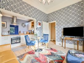 A kitchen with a dining table and television at Muntham Apartment 4 in Torquay