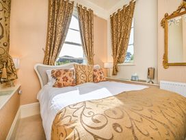 A bedroom with a bed and a mirror at Muntham Apartment 4 in Torquay