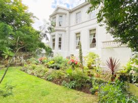 A garden with plants and flowers next to a building at Muntham Apartment 4 in Torquay
