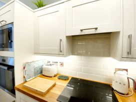 A kitchen with modern appliances and a wooden countertop at Muntham Studio Apartment 5 in Torquay