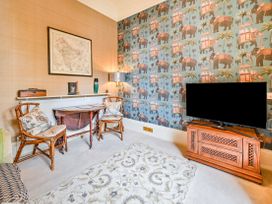 A living room with a rattan chair and television at Muntham Apartment 6 in Torquay