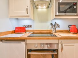 A kitchen with appliances and utensils at Muntham Apartment 6 in Torquay