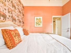 A bedroom with a bed and decorative wallpaper at Muntham Apartment 6 in Torquay