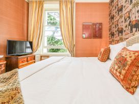 A bedroom with a bed and television at Muntham Apartment 6 in Torquay