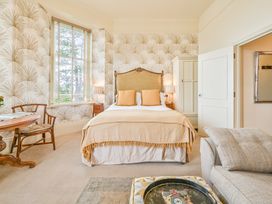 A bedroom with a bed and table at Muntham - Studio Apartment 7 in Torquay