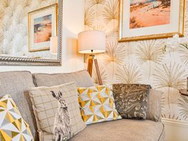 A living room with a sofa and cushions at Muntham - Studio Apartment 7 in Torquay