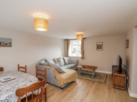 A living room with a sofa and dining table at Starlight Cottage in 