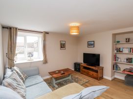 A living room with a sofa and television at Starlight Cottage in 