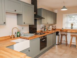 A kitchen with cabinets and a sink at Starlight Cottage 
