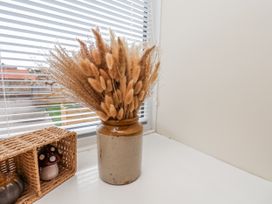 A vase with dried flowers and a woven basket at Starlight Cottage