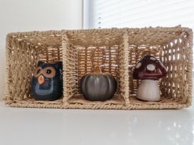 A decorative basket with an owl, pumpkin, and mushroom figurines at Starlight Cottage