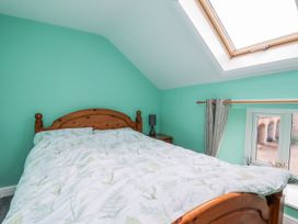 A bedroom with a bed and window at Starlight Cottage