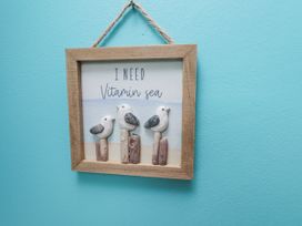 A framed picture with decorative birds and text at Starlight Cottage