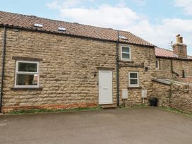 A stone exterior of a cottage with windows and a door at Starlight Cottage 