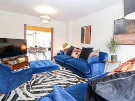 A living room with a blue sofa and television at Manor Park View in Norwich